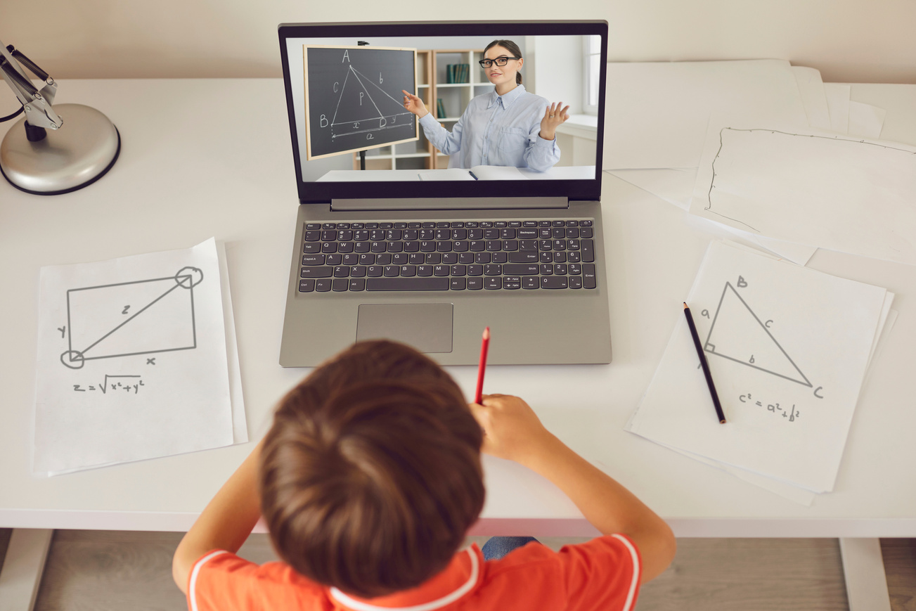 Boy Making Notes during Online Geometry Lesson with Teacher